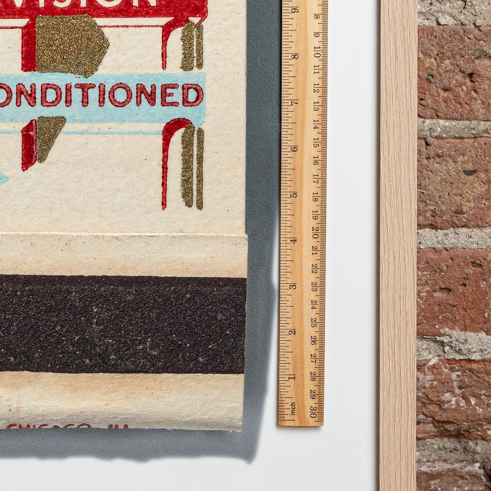 Tip-Top Motel matchbook next to a framed print, for scale